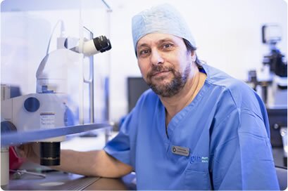 Image of an Origin Fertility Specialist using a microscope